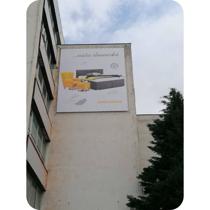 Reklám banner Drevona at épület falára helyezve