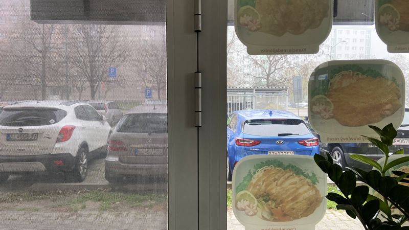 Egy ablak perforált ablakfóliával és egy az nélkül